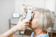 © rh2010 - Doctor measuring the eye pressure with modern tonometer to a senior patient in the medical office, close-up