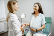 © rh2010 - Young pregnant woman sitting on the gynecological chair during a medical consultation with gynecologist. Cheerful doctor supporting and comforting patient