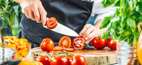 Fotomural Koch schneidet frische rote Tomaten in Restaurant küche
