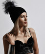 © Dmitry Lobanov - Fashion art portrait of glamour style woman blonde in plush bralet and winter hat standing with her hand at her shoulder