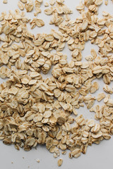 Scatterd raw oat-flakes on white background