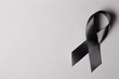 Black ribbon on a gray background. Mourning. Sorrow.