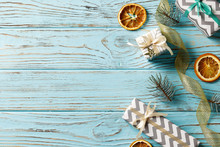 Composition Of Christmas Gift Boxes, Snow, Pine Cone, Fir Branches, Dried Orange Fruits, On A Blue Wooden Background. Place For Text. Top View. Holiday, Christmas, Birthday.