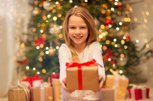 Christmas, Holidays And Childhood Concept - Smiling Girl With Gift Box At Home