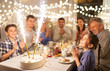 © Syda Productions - celebration, birthday and people concept - happy family having dinner party with fountain fireworks or sparkler candles burning on cake at home