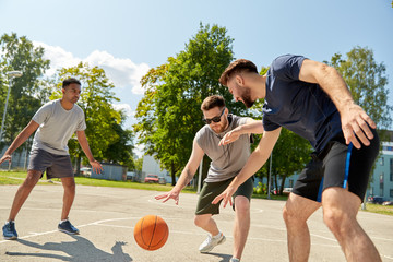 sport, leisure games and male friendship concept - group of men or friends playing street basketball