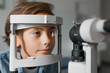 © InsideCreativeHouse - Close up shot of boy checking vision with tonometer at eye clinic