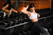 © FAB.1 - Cute sports girl brunette is sitting in the gym near the mirror next to the bowties. Break in training.