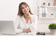 © Prostock-studio - Smiling Businesswoman Sitting At Laptop Posing At Workplace