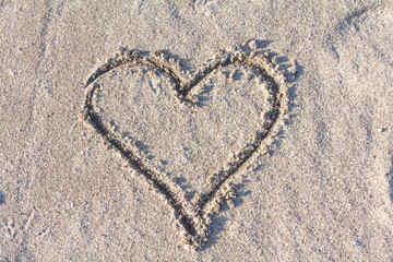 an I love you heart drawn in the sand on a beach with a stick