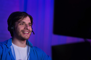 Poster - Happy young gamer in headphones playing computer game