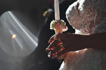 Bride holding candle during an orthodox wedding ceremony