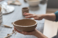 Clay Pottery Workshop, The Process Of Making Ceramic Crockery. Woman Hand Holding Raw Clay Plate
