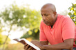 © digitalskillet1 - African American man praying and reading the Bible.