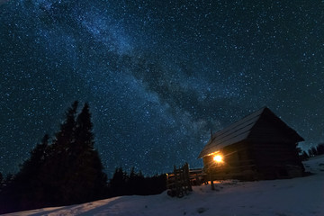 Wall Mural - fairytale landscapes of the winter carpathian mountains with a charming milky way in the sky tourist