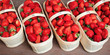 Fresh strawberries in the basket on the wooden stall of a farmer's market