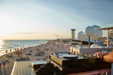 Dj's sound equipment and people on blurred background. Summer music festival on beach