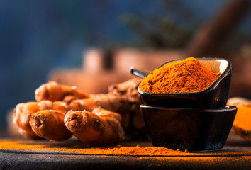 Wall Mural - Turmeric powder and fresh turmeric on wooden background