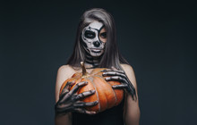 Female Undead Holding Pumpkin During Halloween Party