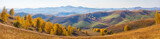 Fototapeta Niebo - Wide panoramic view, autumn. The picturesque valley. Forested slopes and mountains in the distance in a blue haze.