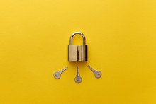 Top View Of Metal Padlock With Keys On Yellow Background