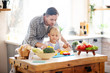 © zinkevych - Father helping daughter to use knife while cutting vegetables