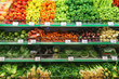 Pattern laid out organic vegetables, fruits and herbs on shelves at farmers marketin the city. Bright colors of healthy food broccoli, lettuce, eggplant, zucchini, onions, peppers, garlic, tomatoes