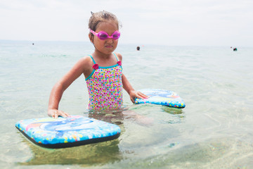 Wall Mural - Little girl with swimming goggles ready for swimming during summer vacation