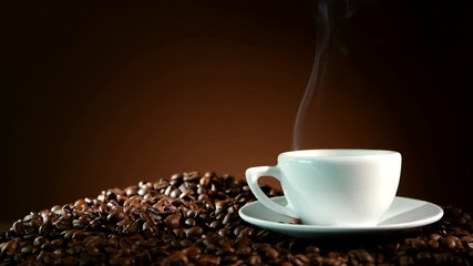 Wall Mural - Cup of espresso with coffee beans and steam on dark background