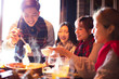 © Tom Wang - happy young friends eating hot pot in restaurant at winter