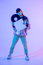The Girl With The Vinyl Record. Colored Background And Neon Light. Modern Clothes. Music Poster. Retro Concept.