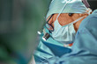 © Georgii - Close up portrait of female surgeon doctor wearing protective mask and hat during the operation. Healthcare, medical education, surgery concept.