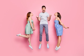 Poster - Full size profile side photo of screaming person with raised fists and charming ladies kissing him wearing striped t-shirt pants isolated over pink background