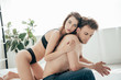 © LIGHTFIELD STUDIOS - attractive girlfriend in black underwear hugging handsome boyfriend in bed