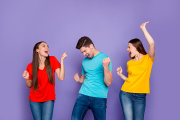 Portrait of nice attractive lovely charming cheerful cheery careless carefree overjoyed guys wearing colorful t-shirts jeans having fun event free time isolated over violet lilac background