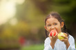 © prasit - child eating apple little girl playing peek a boo holding fresh ripe apples