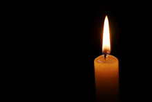 Dramatic Burning Candle Flame On A Black Background With Copy Space