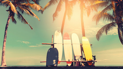 Surfboard and palm tree on beach background.