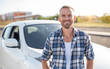 © Denis Rozhnovsky - An attractive young man stands near a white car.