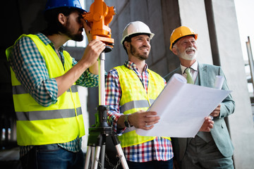 Confident team of architects and engineers working together on construction site