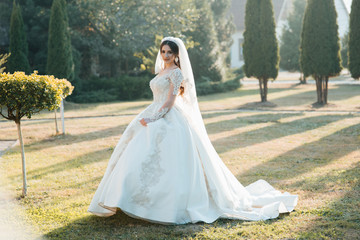 Beautiful bride outdoors on a wedding day. Joyful moment of happiness. Beautiful young bride, nature wedding concept. Bride in white dress with departure. Wedding day. 