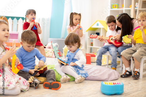 Fotografía Kindergarten teacher with children on music lesson in day care