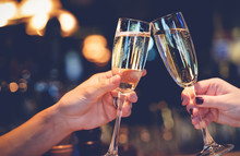 Two Glasses With Sparkling Champagne Wine In Hands, Concept For Holiday, Wedding Valentines Christmas And New Year, Bokeh, In A Restaurant And Cafe