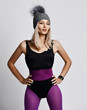 © Dmitry Lobanov - Stylish athletic blonde woman in purple sports wear, gray winter hat is standing, looking at something in the distance