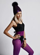 © Dmitry Lobanov - Portrait in profile of stylish athletic blonde woman in purple sports wear, winter hat and smart watches on her hand