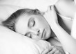 © Nataly Reinch - Sleep. Beautiful young woman sleeping in bed. Morning. Attractive girl rests in bed on a pillow. Peaceful sleep. Hugging. Close up. Black and White Photography. Classic Photo. Background.