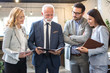 © Bojan - Group of multi-aged business people analyzing paper documents together in office