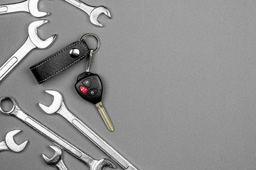 Set of spanner and a car key with remote control on the floor. - maintenance and care before traveling concept.