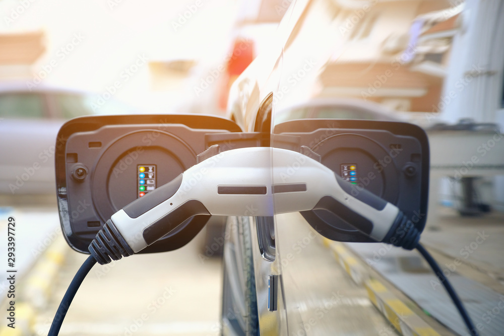 Charging modern electric car battery on the street which are the future of the Automobile, Close up of power supply plugged into an electric car being charged for hybrid . New era of vehicle fuel.