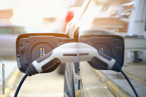 Fotografía Charging modern electric car battery on the street which are the future of the Automobile, Close up of power supply plugged into an electric car being charged for hybrid